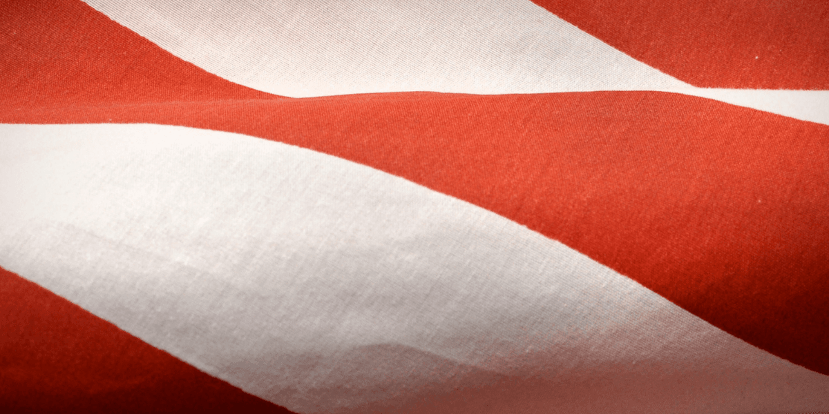 Red and white fabric with diagonal stripes gently folded and wrinkled
