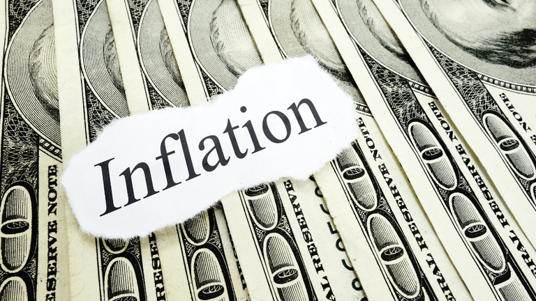A collage of dollar bills with the word "Inflation" printed on paper overlay.