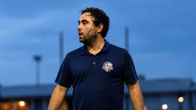 Brad Namdar on the sideline wearing Texas Lone Star S.C. polo during a match.