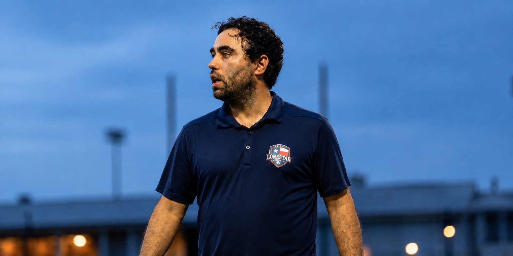 Brad Namdar on the sideline wearing Texas Lone Star S.C. polo during a match.