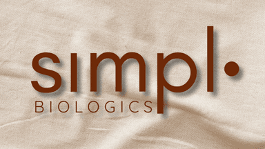 Simpl.bio logo with earthy brown text against a soft beige fabric background, symbolizing a clean, empowering wellness brand for women.