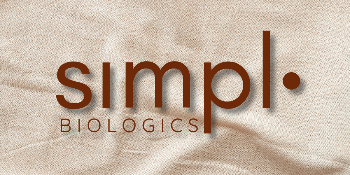 Simpl.bio logo with earthy brown text against a soft beige fabric background, symbolizing a clean, empowering wellness brand for women.