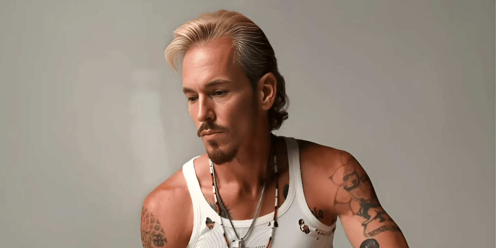 C.J. Shaman, a rising rock and country artist, photographed with a contemplative expression. Known for his raw, rebellious sound and deeply personal music, Shaman combines classic rock energy with modern influences, captivating audiences with his authentic performances and powerful lyrics.