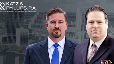 Two suited men in front of a city skyline with the Katz & Phillips, P.A. logo above them.