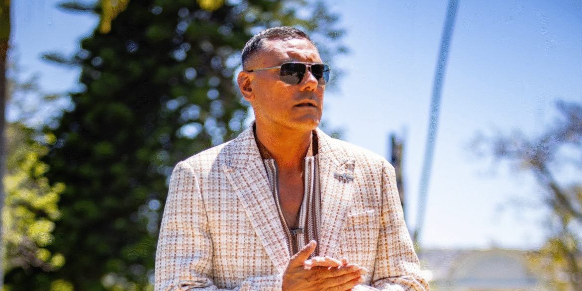 Dylan Garcia, a talented musician and mental health advocate, posing outdoors in a stylish outfit. Known for his unique blend of funk and Neo-Soul, Dylan uses his platform to raise awareness for mental health, encouraging open conversations and supporting individuals through his music and advocacy work