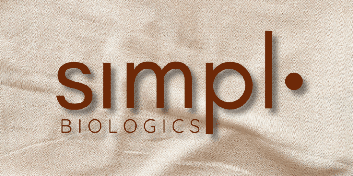 Simpl.bio logo with earthy brown text against a soft beige fabric background, symbolizing a clean, empowering wellness brand for women.