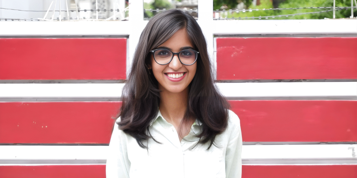 Raj Lakshmi Sharma, a young author, smiling in front of a red and white background, representing her poetry journey.