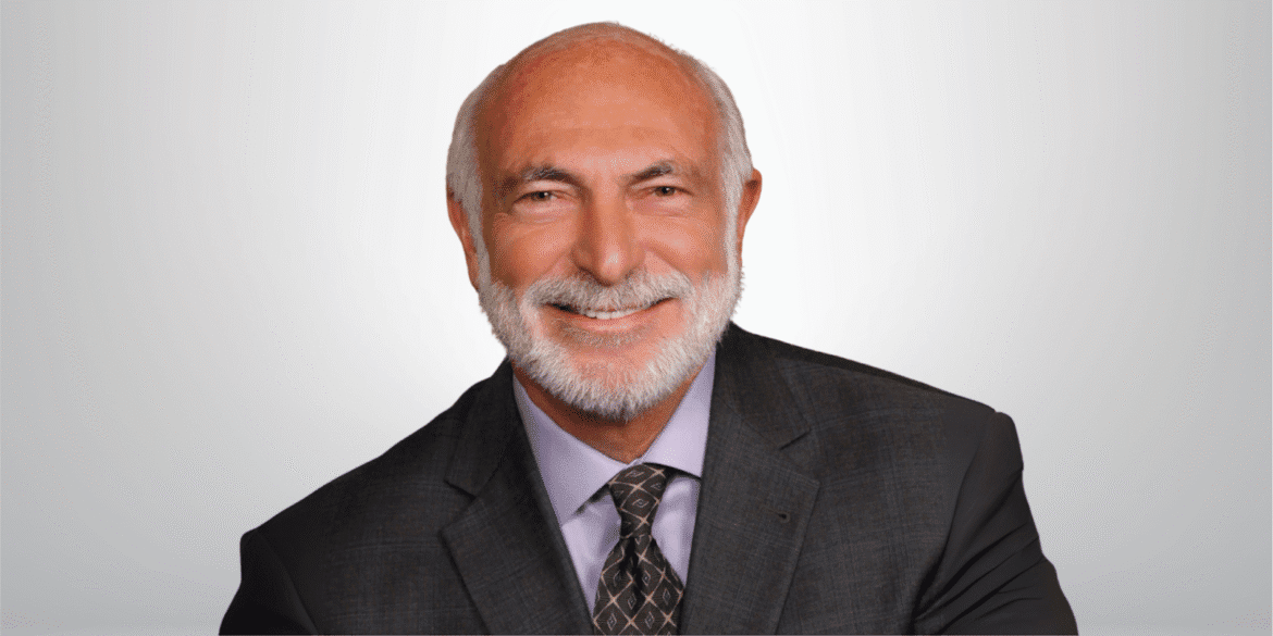 Dr. Michael J. Cooper smiling in a suit, symbolizing his dual roles as physician and peace-focused historical fiction author.
